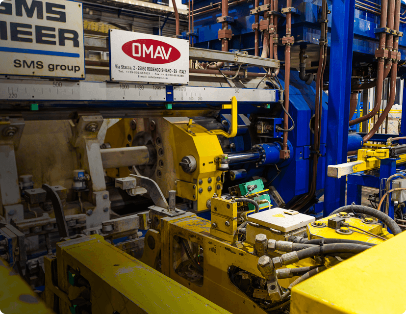 Industrial machinery processes material; factory setting.